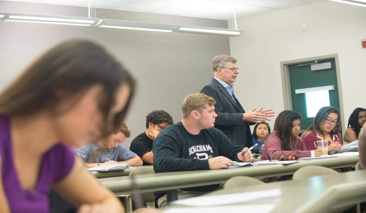 a person standing in front of a group of students