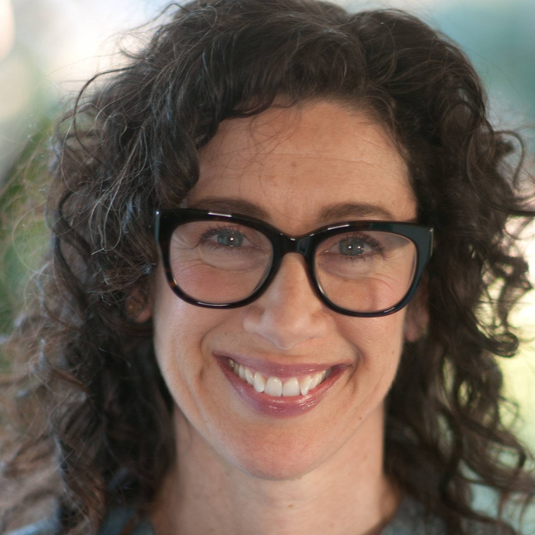a person with curly hair wearing glasses