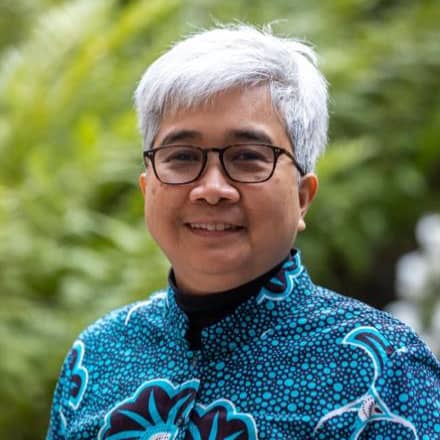 a person with glasses smiling