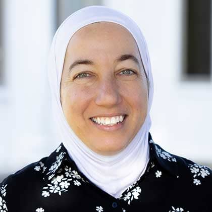 a person wearing a white scarf and black shirt