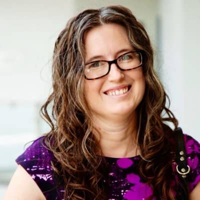 a person wearing glasses and a purple dress