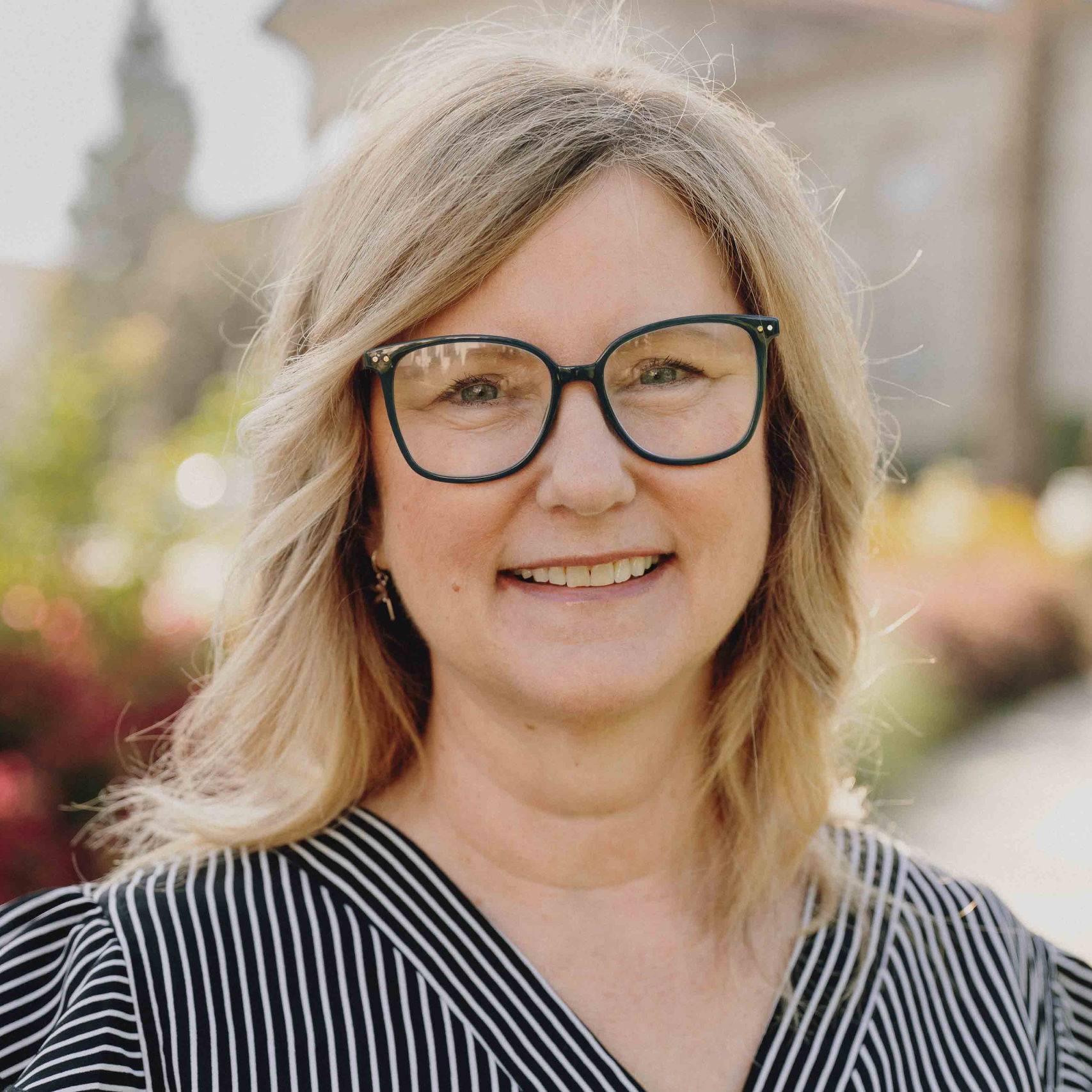 a person wearing glasses and smiling