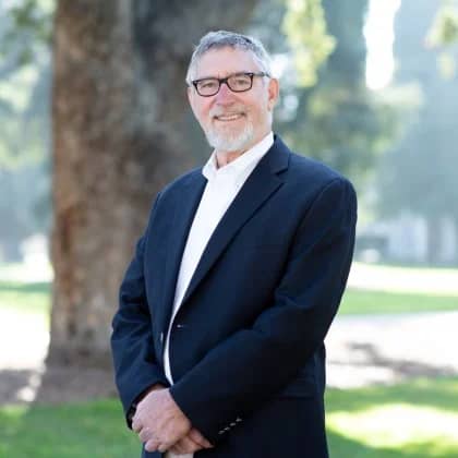 a person in a suit standing in a park
