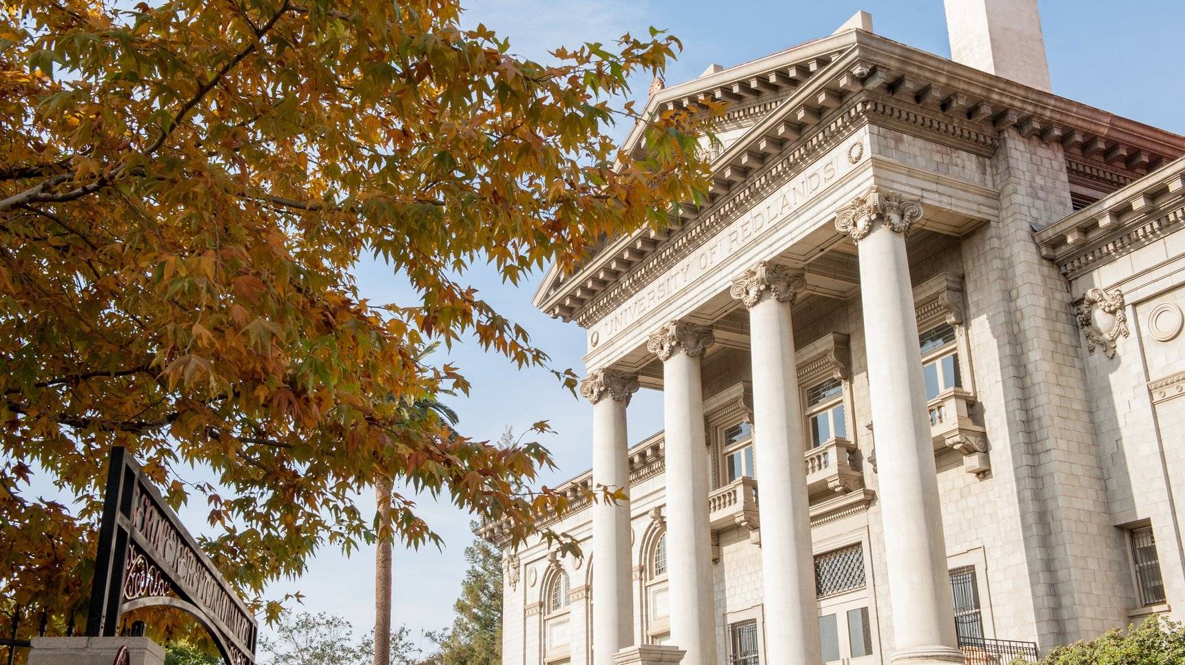 a building with columns and a tree
