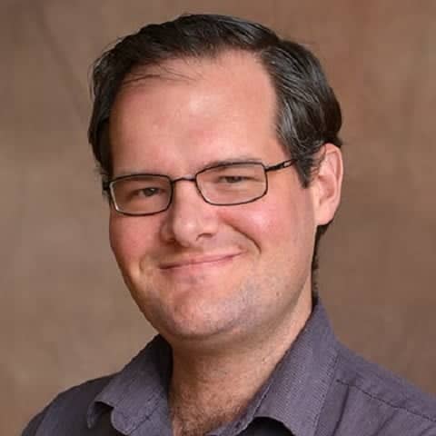 a person wearing glasses and a purple shirt