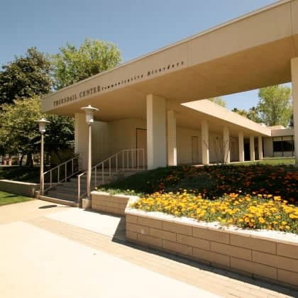 a building with a walkway and flowers