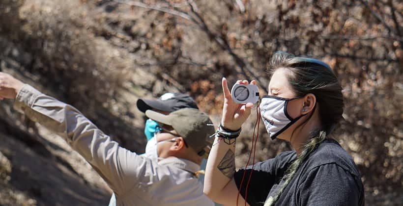 a person wearing a face mask and holding a compass