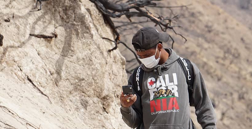 a person wearing a mask and looking at a phone