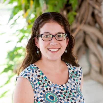 a person wearing glasses and a blue and white dress