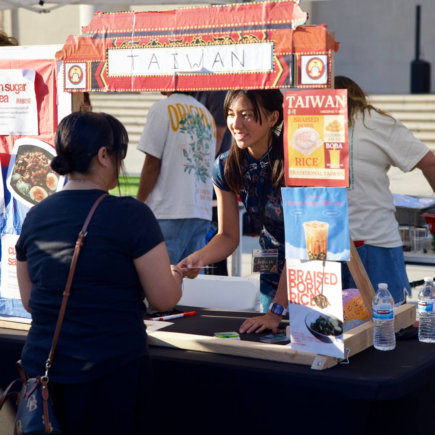 a person shaking hands with a person at a food stand