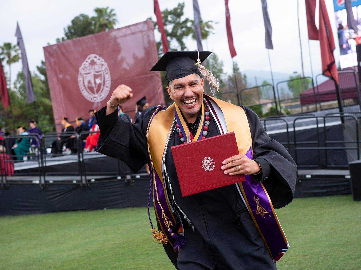 a person in a graduation gown holding a diploma