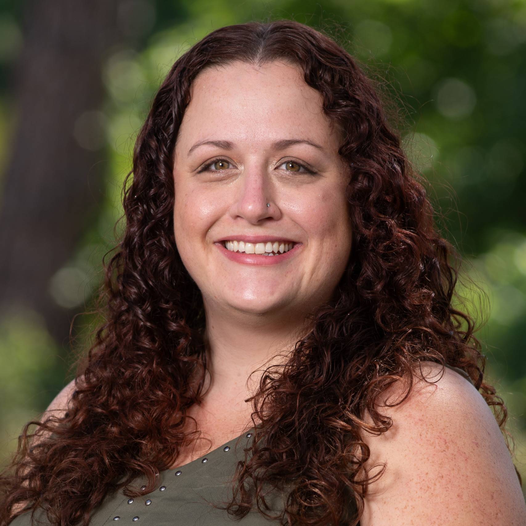 a person with long curly hair smiling