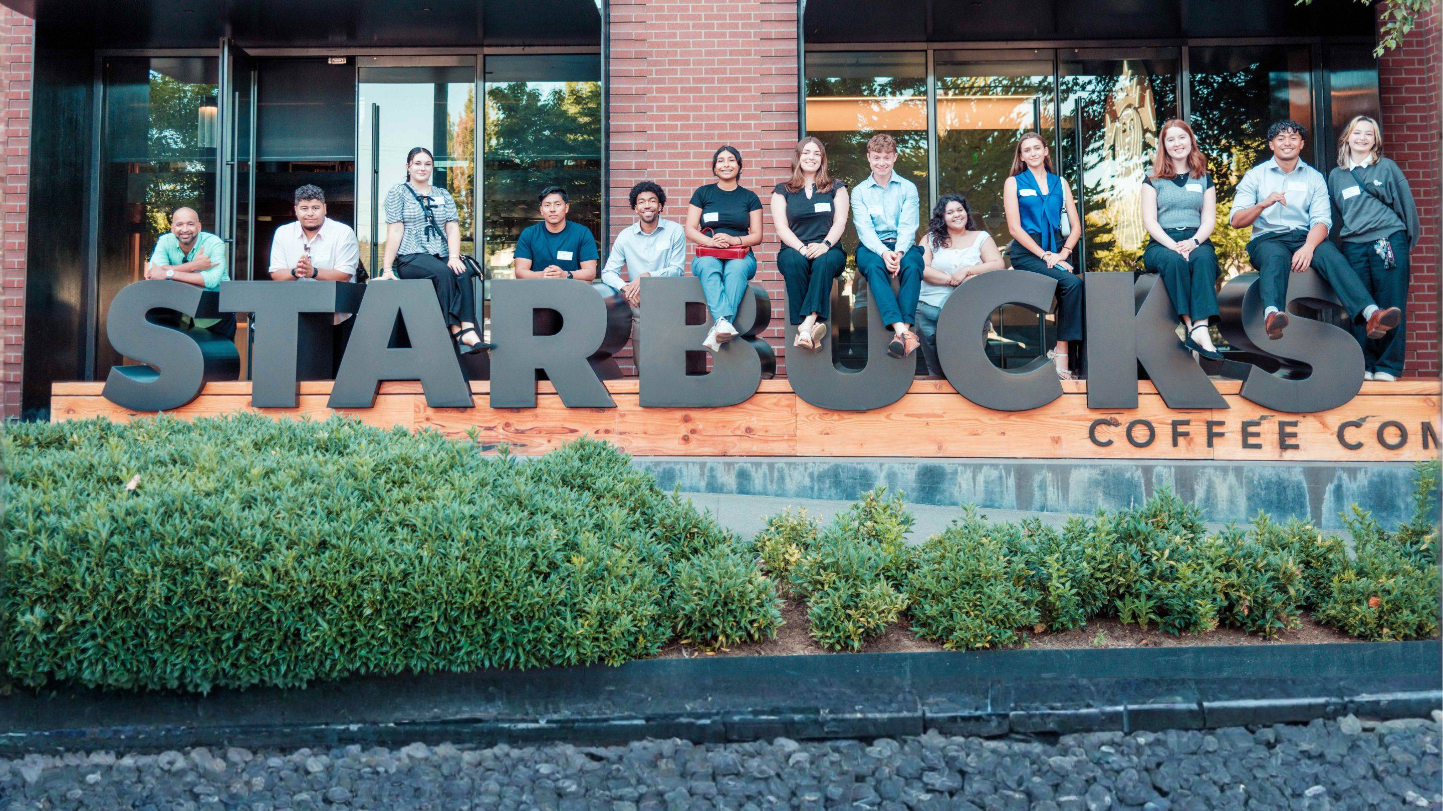 a group of people sitting on a bench in front of a building