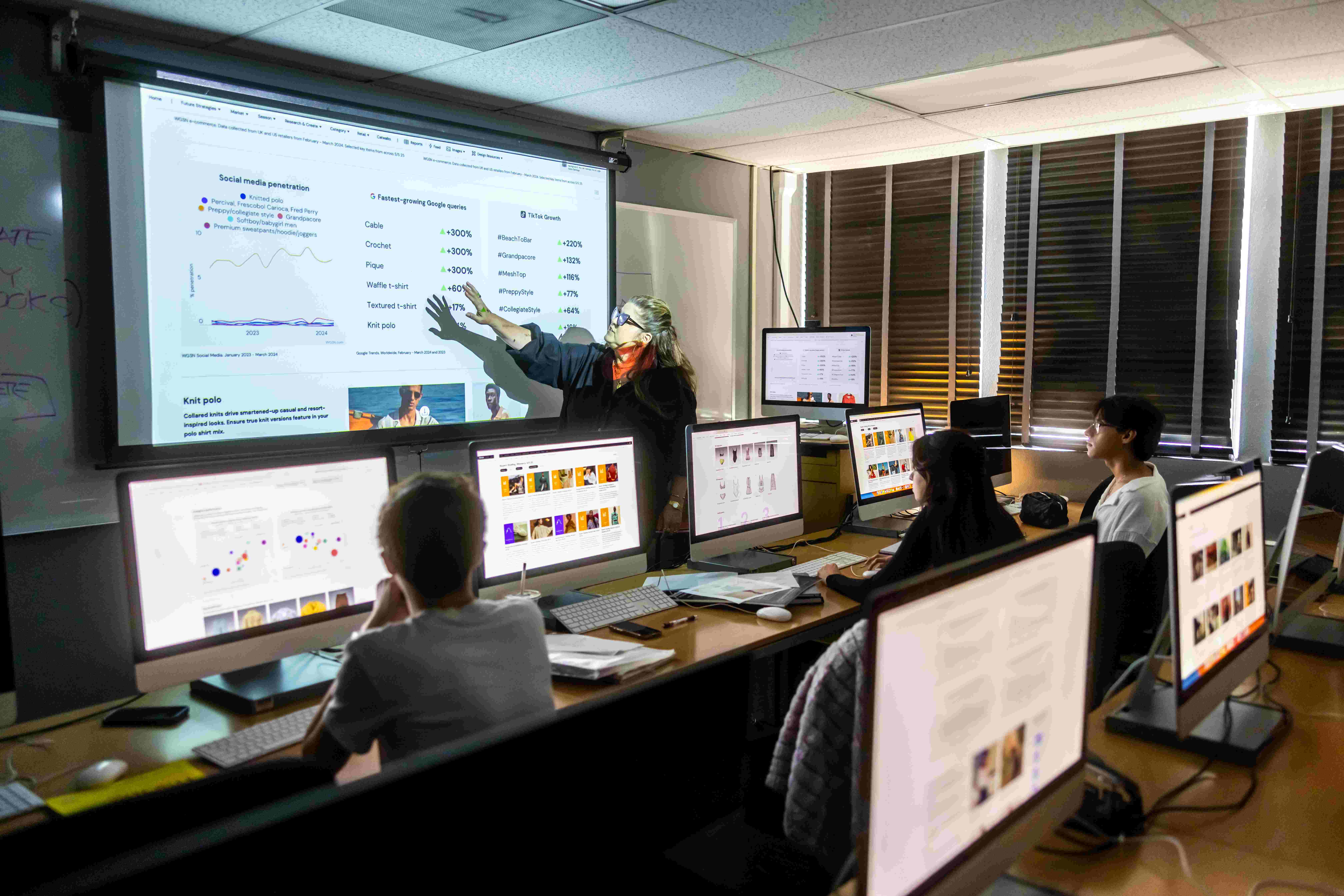 a group of people sitting at desks with computers