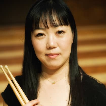 a person holding drumsticks in her hand