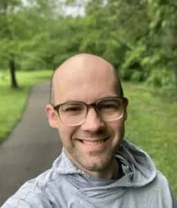 a person wearing glasses and a grey sweatshirt