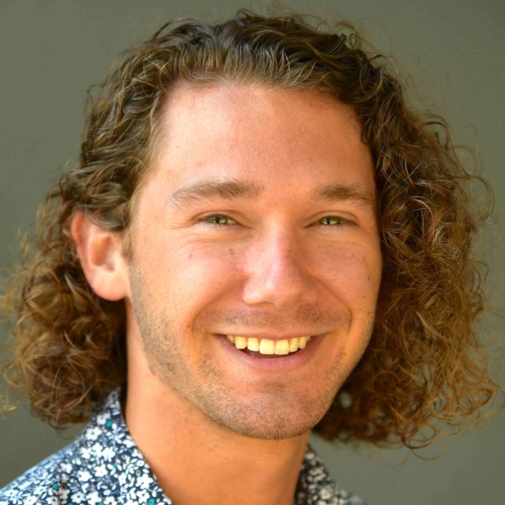 a person with curly hair smiling