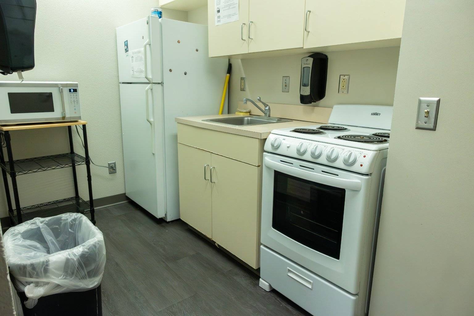 a kitchen with white cabinets and stove