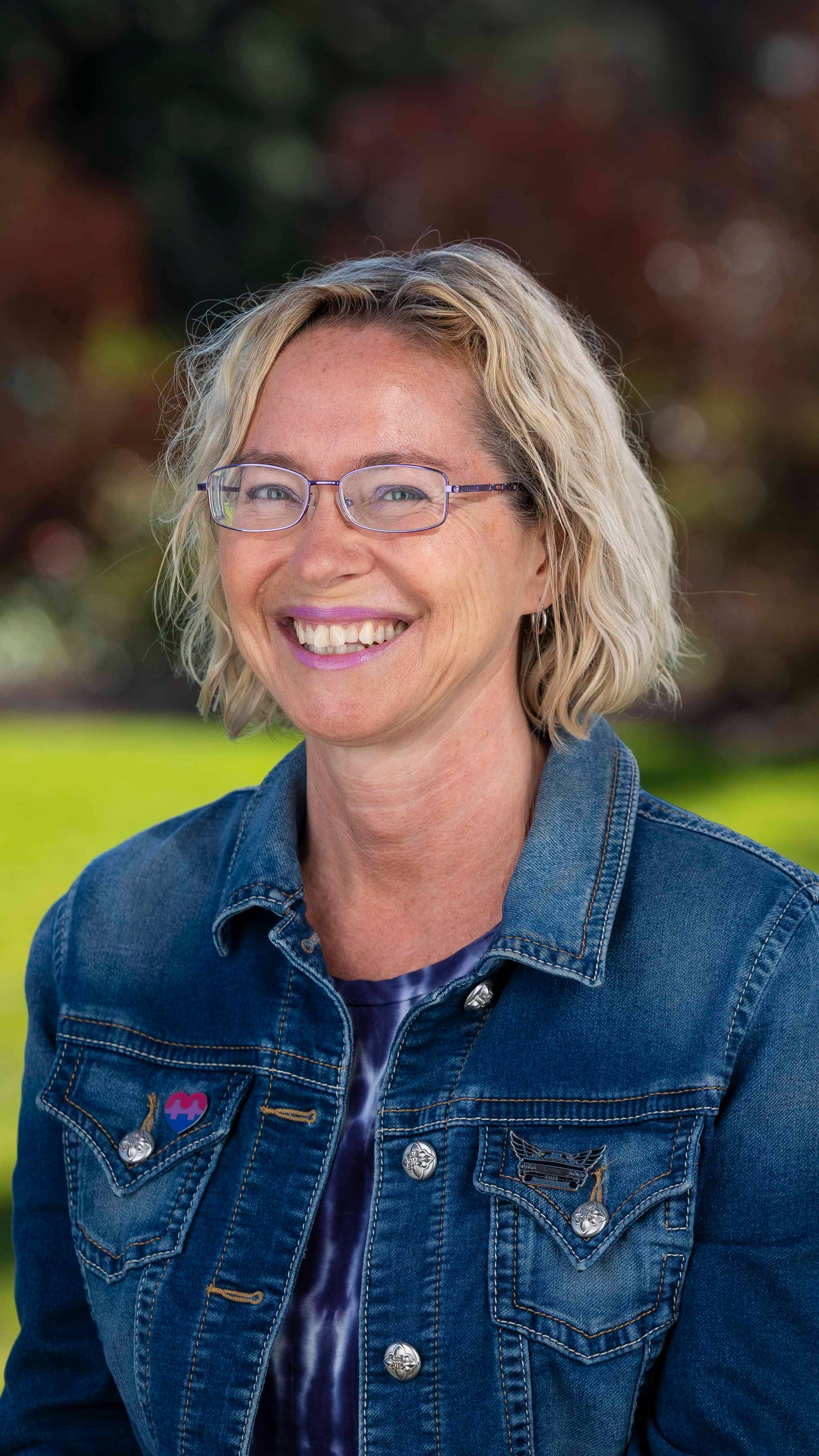 a person wearing glasses and a denim jacket