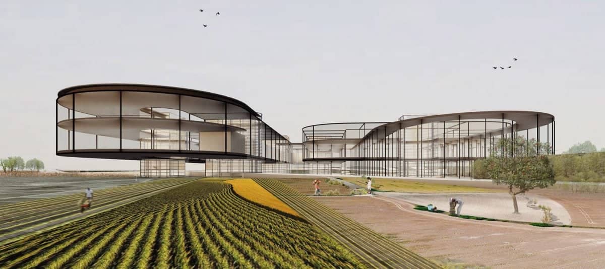 a building with curved glass walls and a field