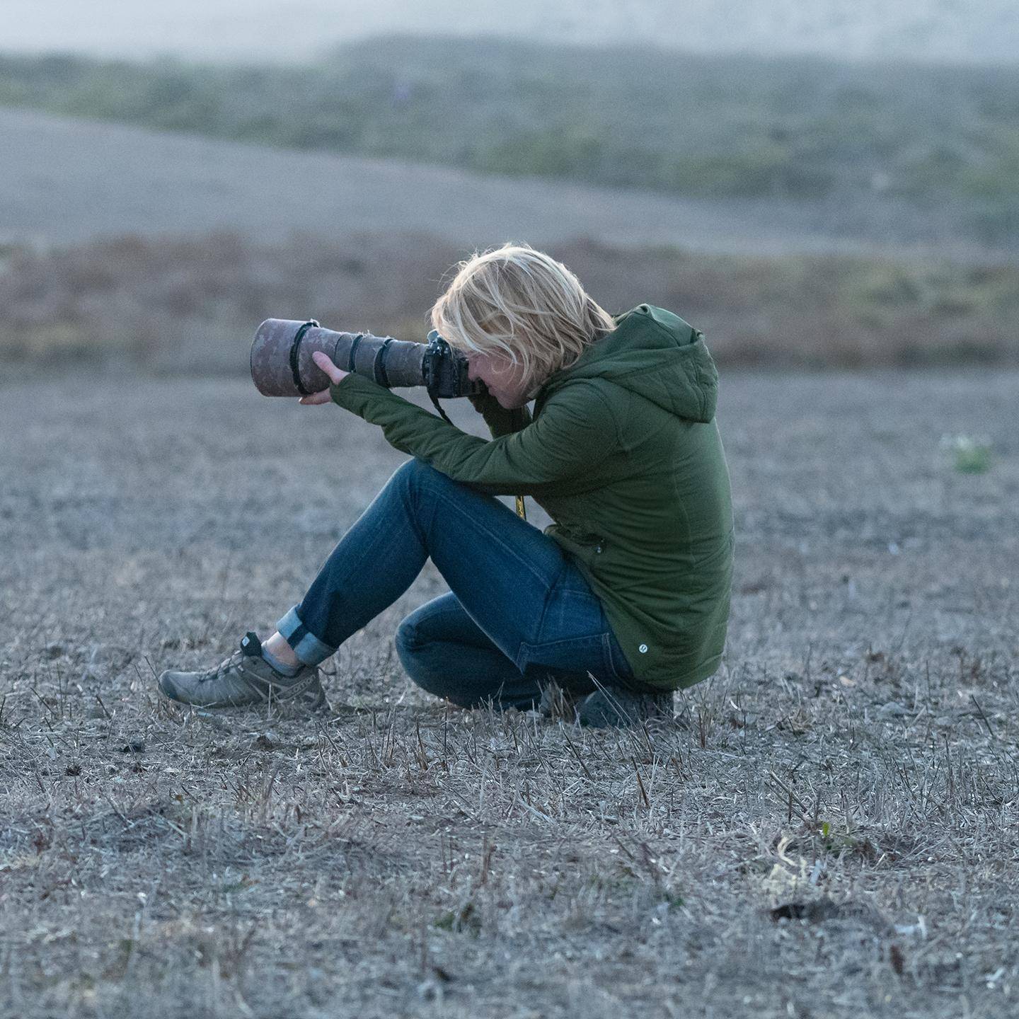 a person sitting on the ground holding a camera
