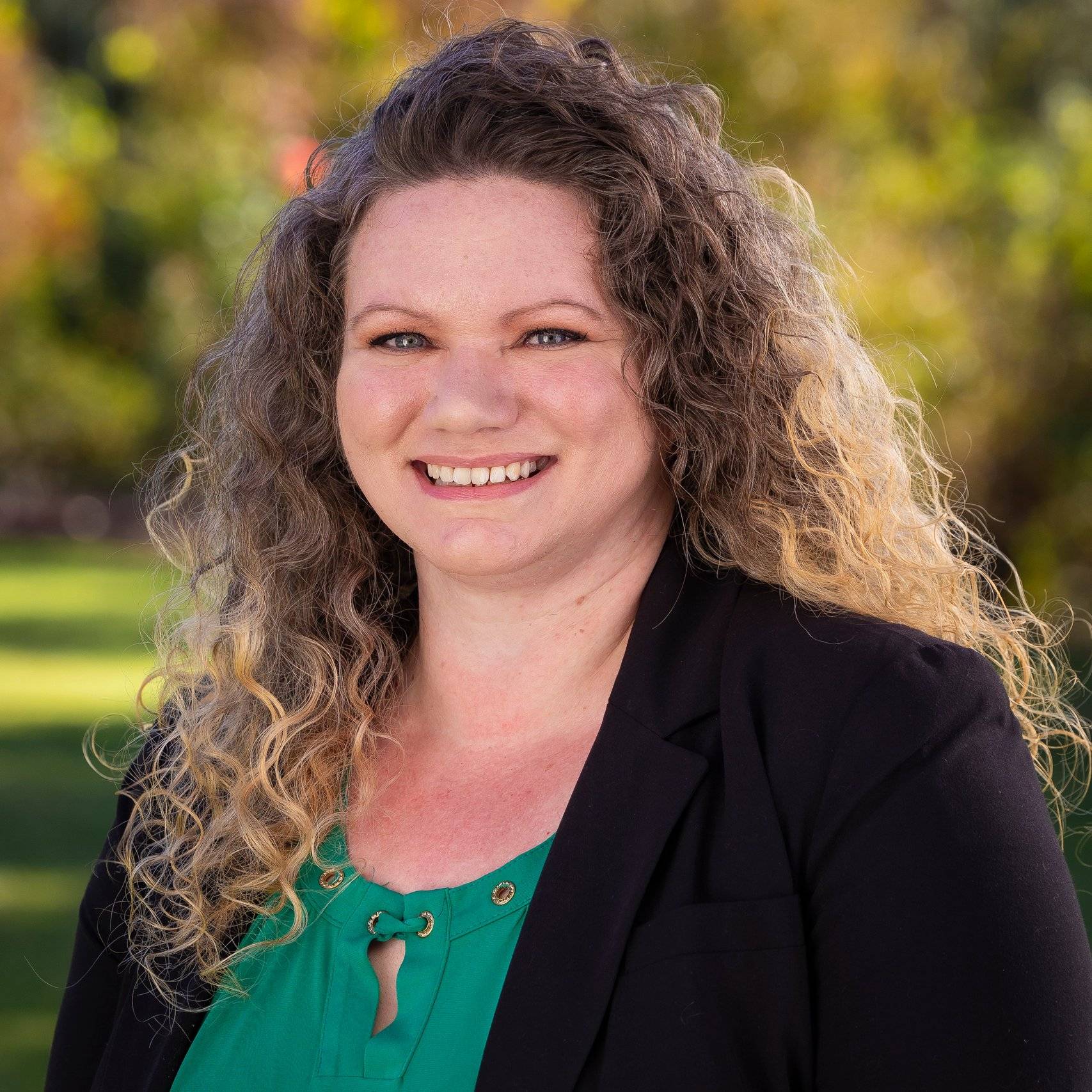 a person with curly hair smiling