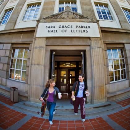 two women walking in front of a building