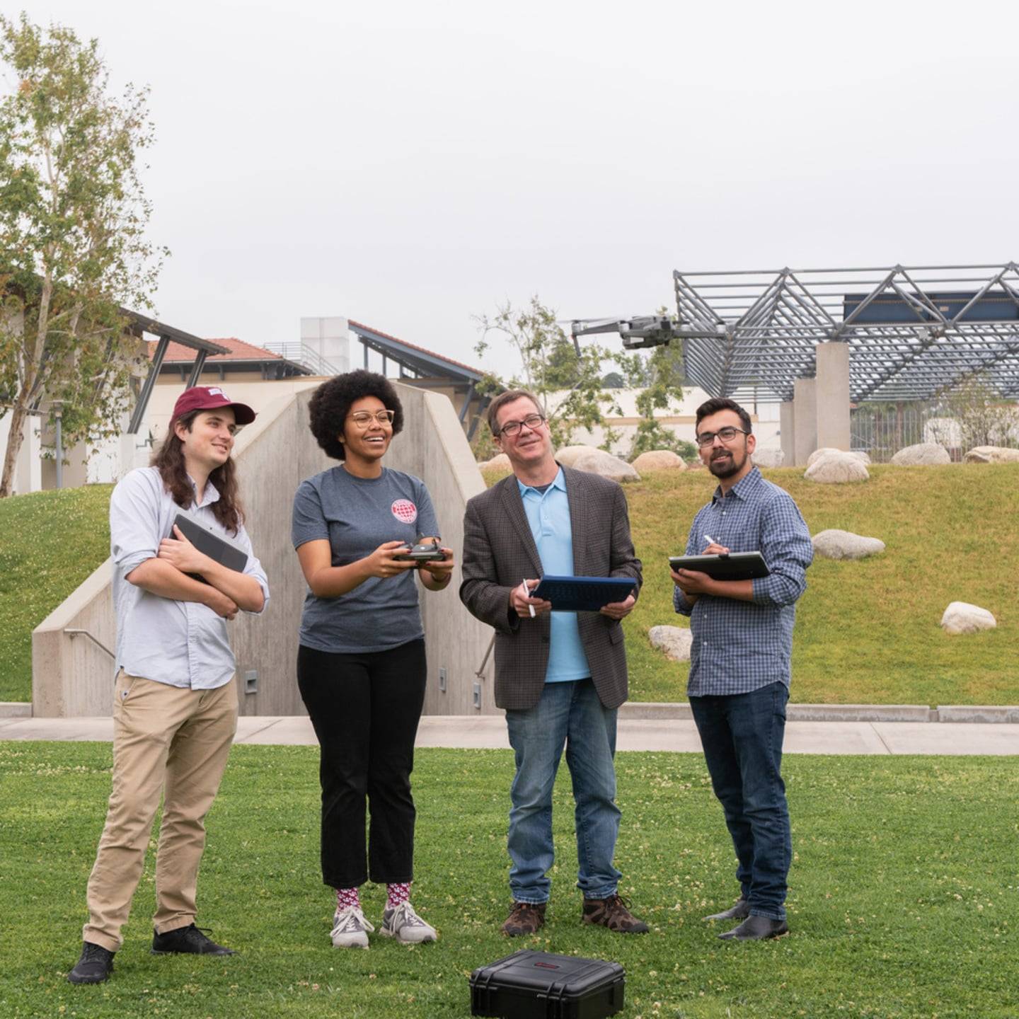 Students and instructor flying a drone near Lewis Hall.