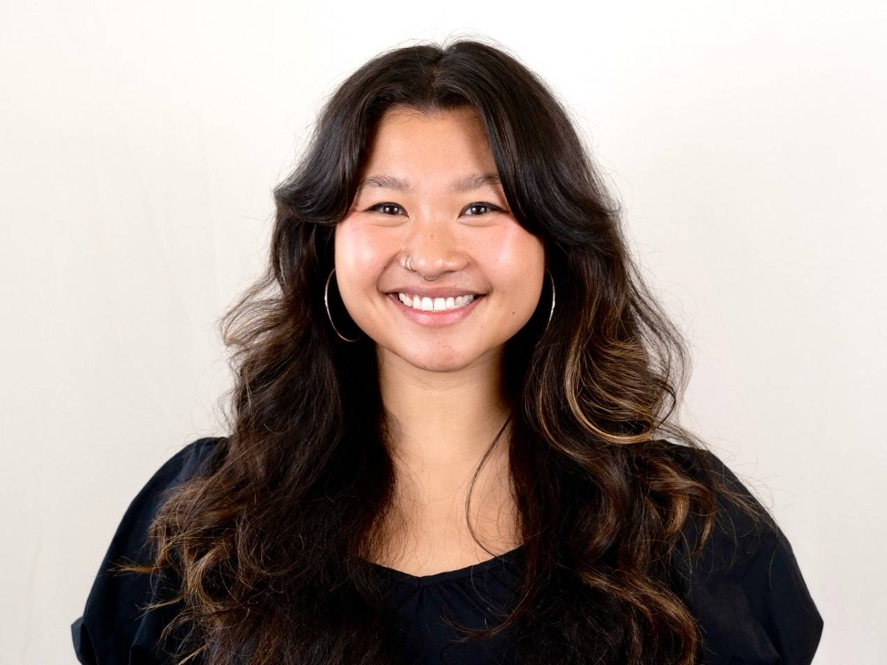 a person with long hair smiling