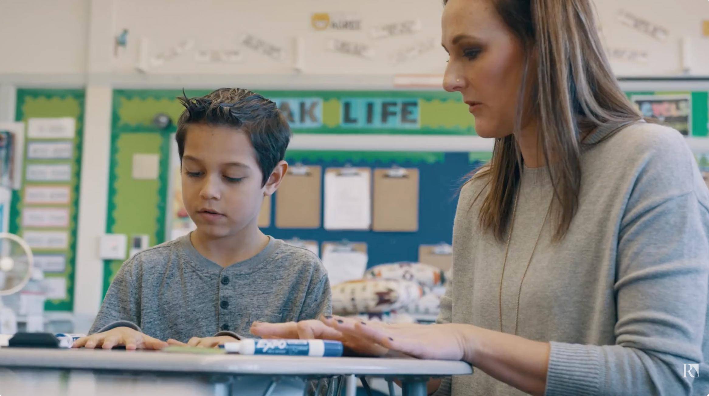 a person and a child sitting at a desk