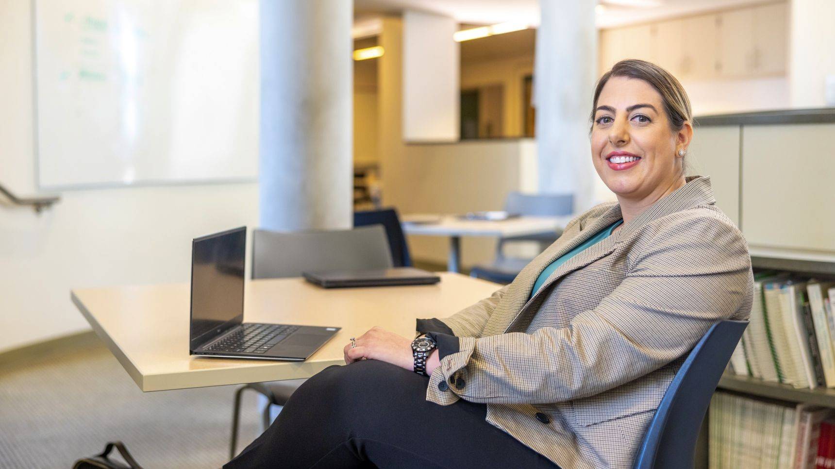 a person sitting at a table with a laptop