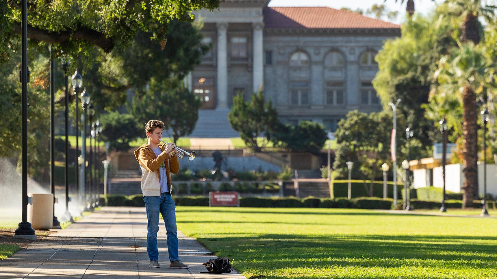 a person playing a trumpet in a park