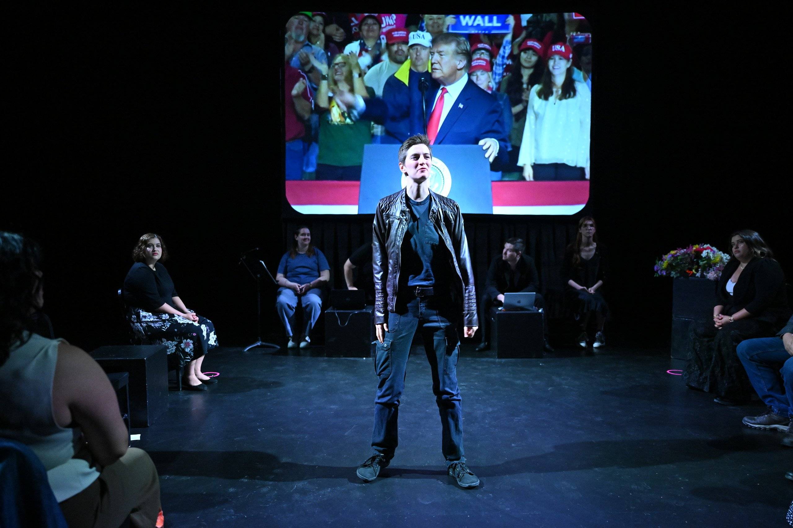 a person standing on a stage with a crowd watching