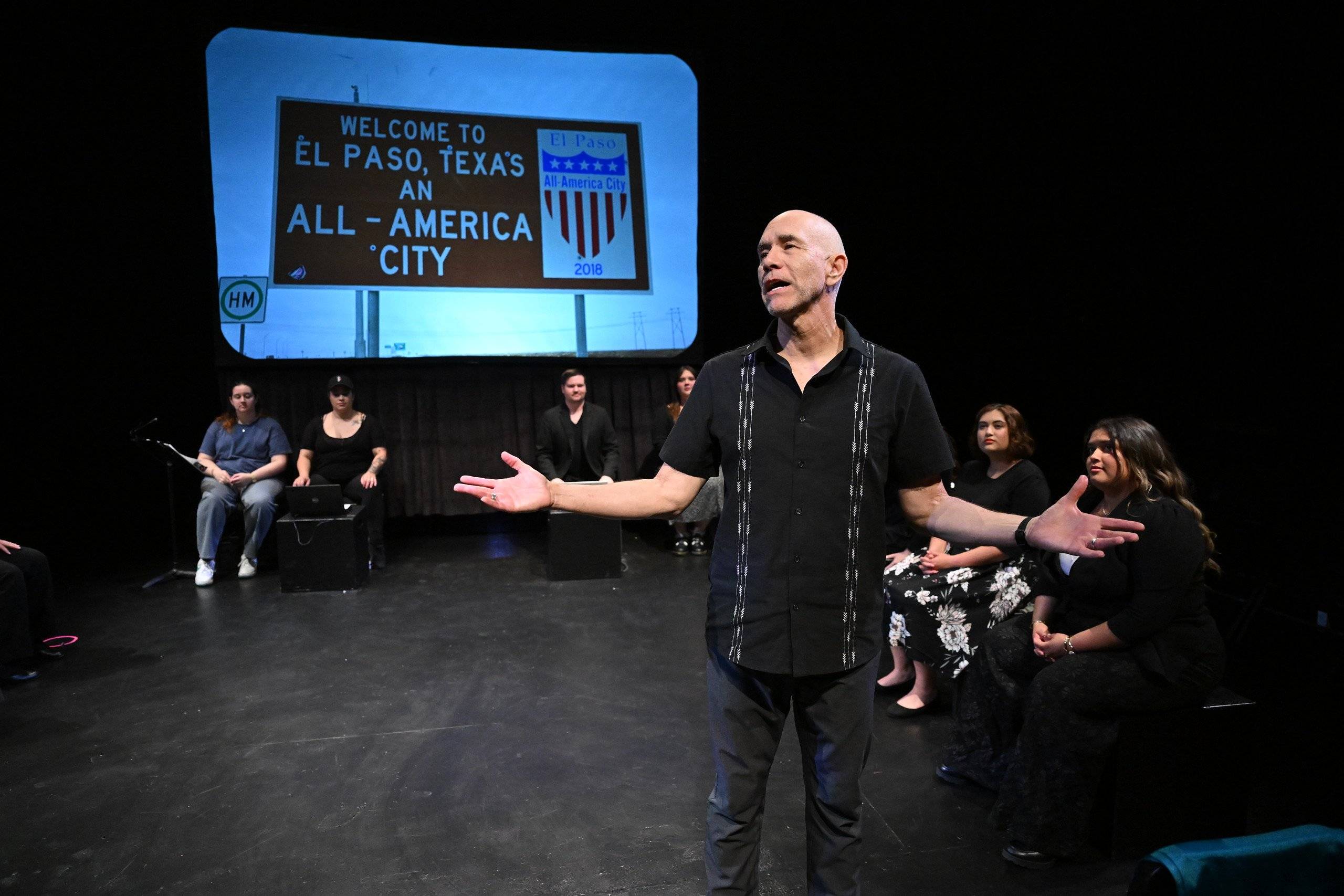 a person standing on a stage with his arms out