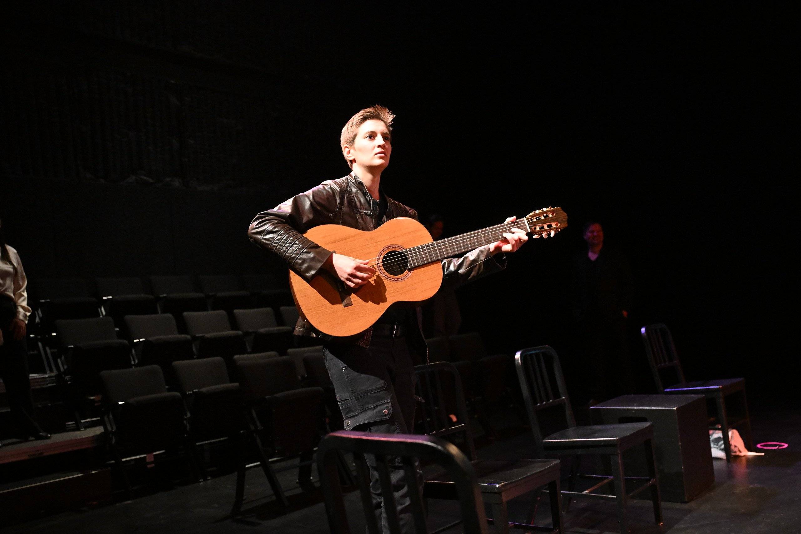 a person playing a guitar in a dark room