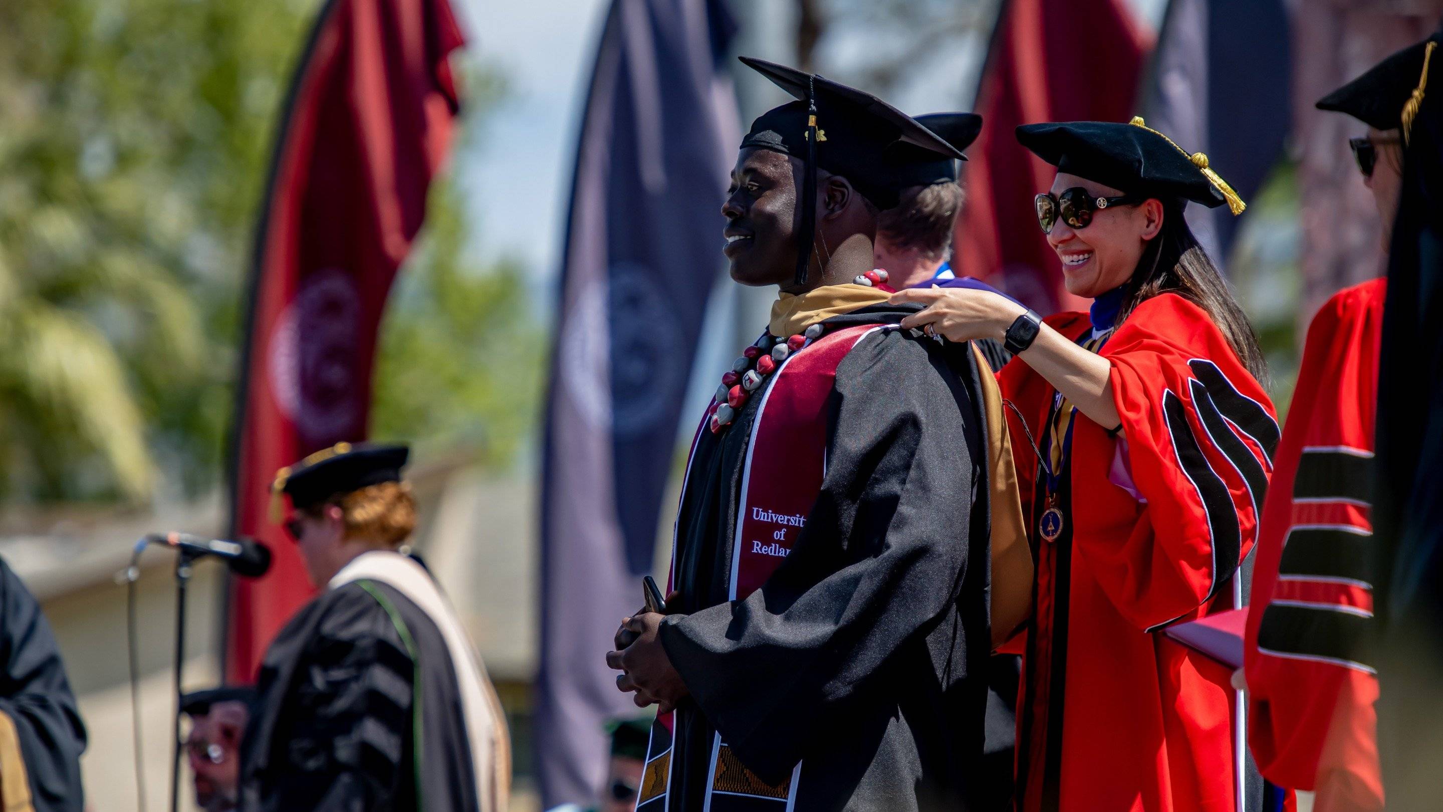 a person putting on a graduation gown