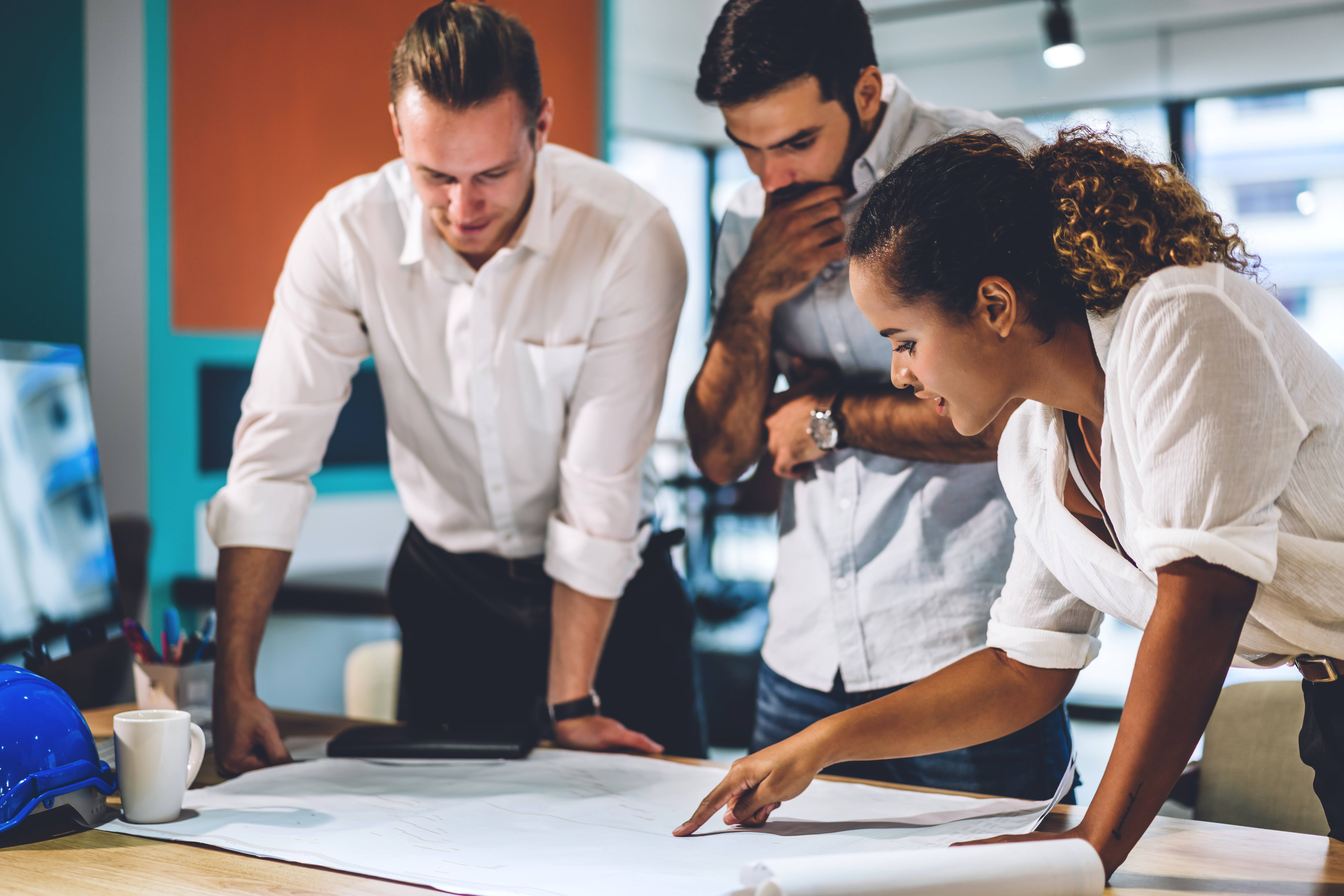 a group of people looking at a blueprint