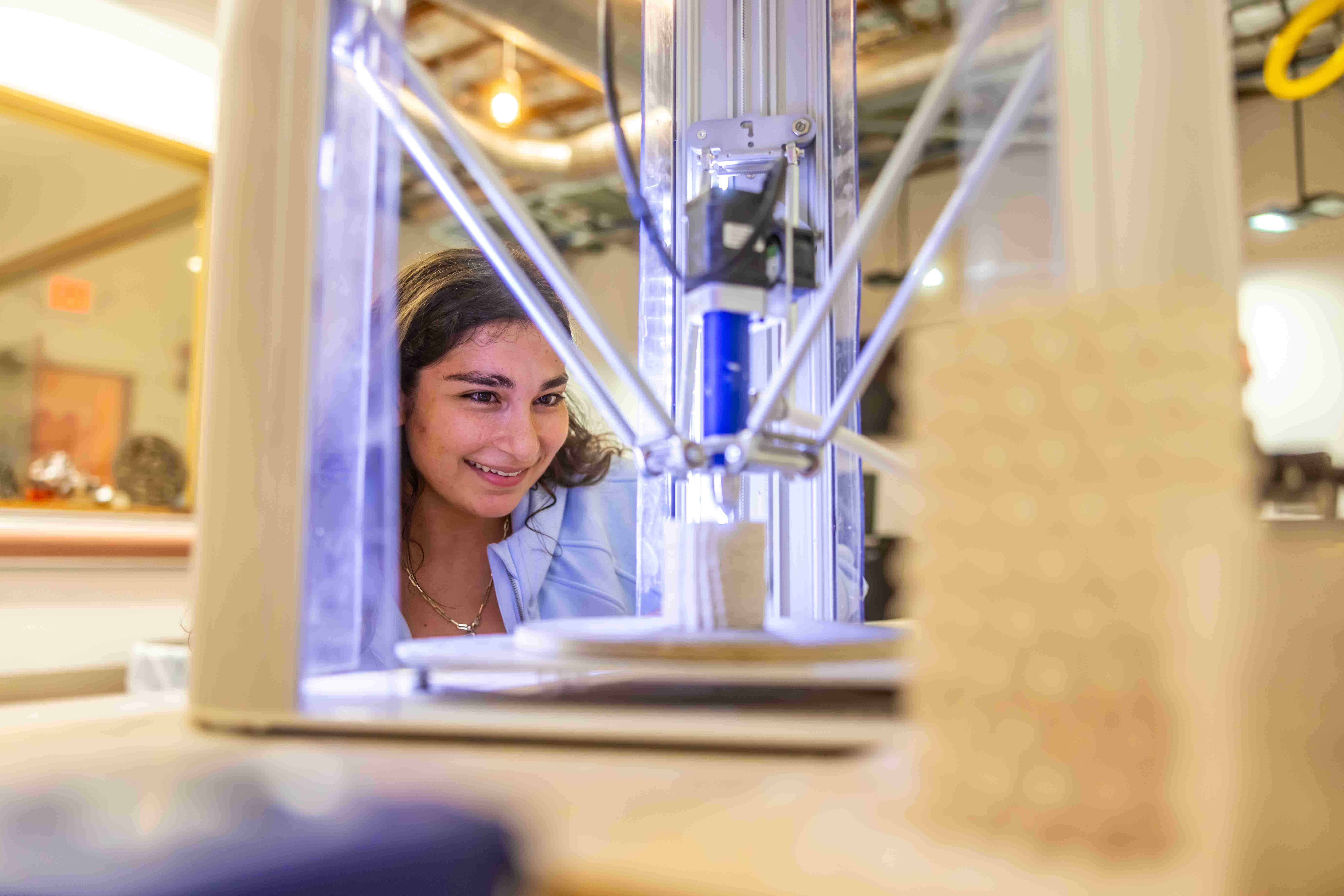 a person looking at a 3D printer machine