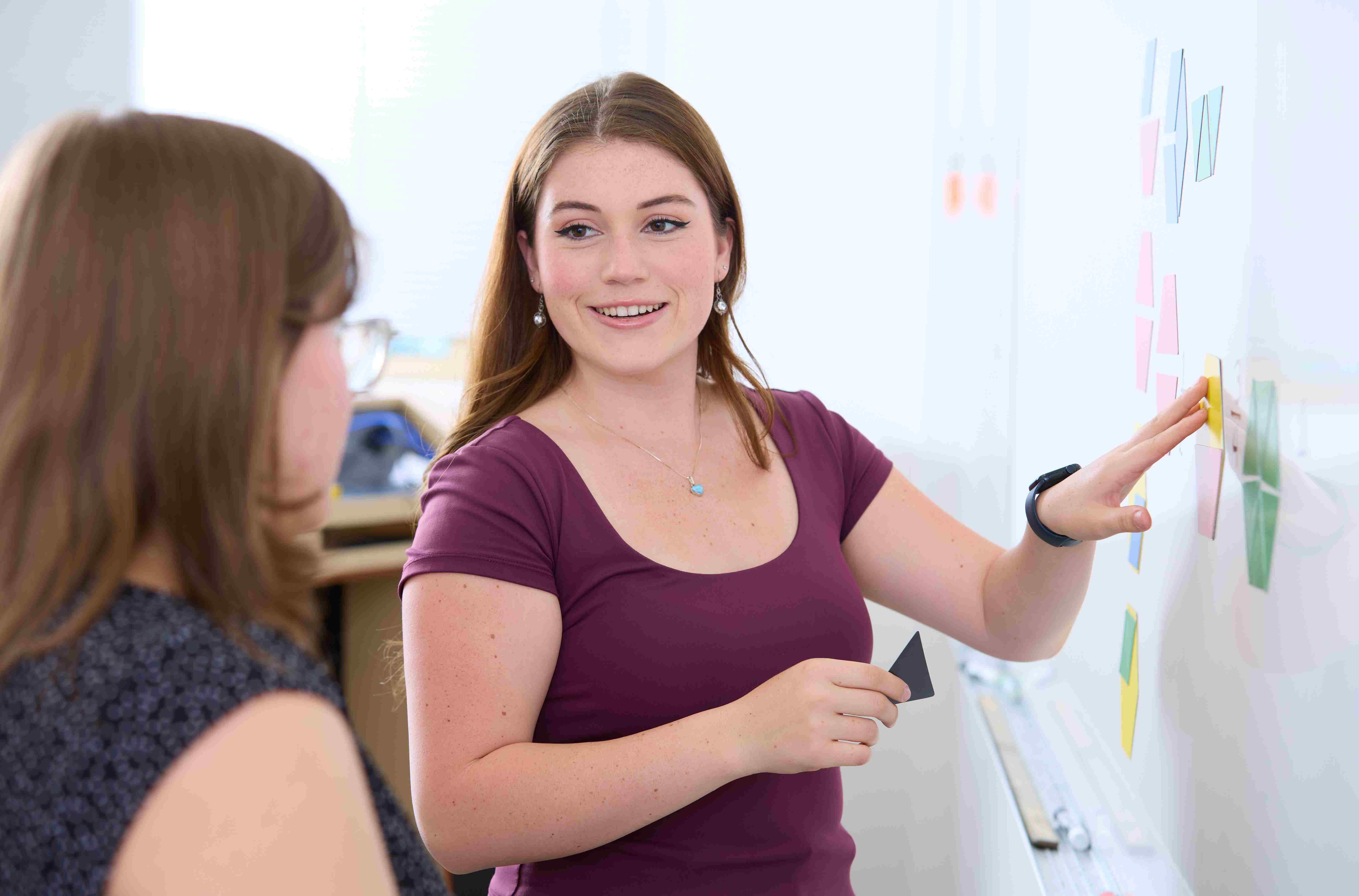 a person standing in front of a whiteboard