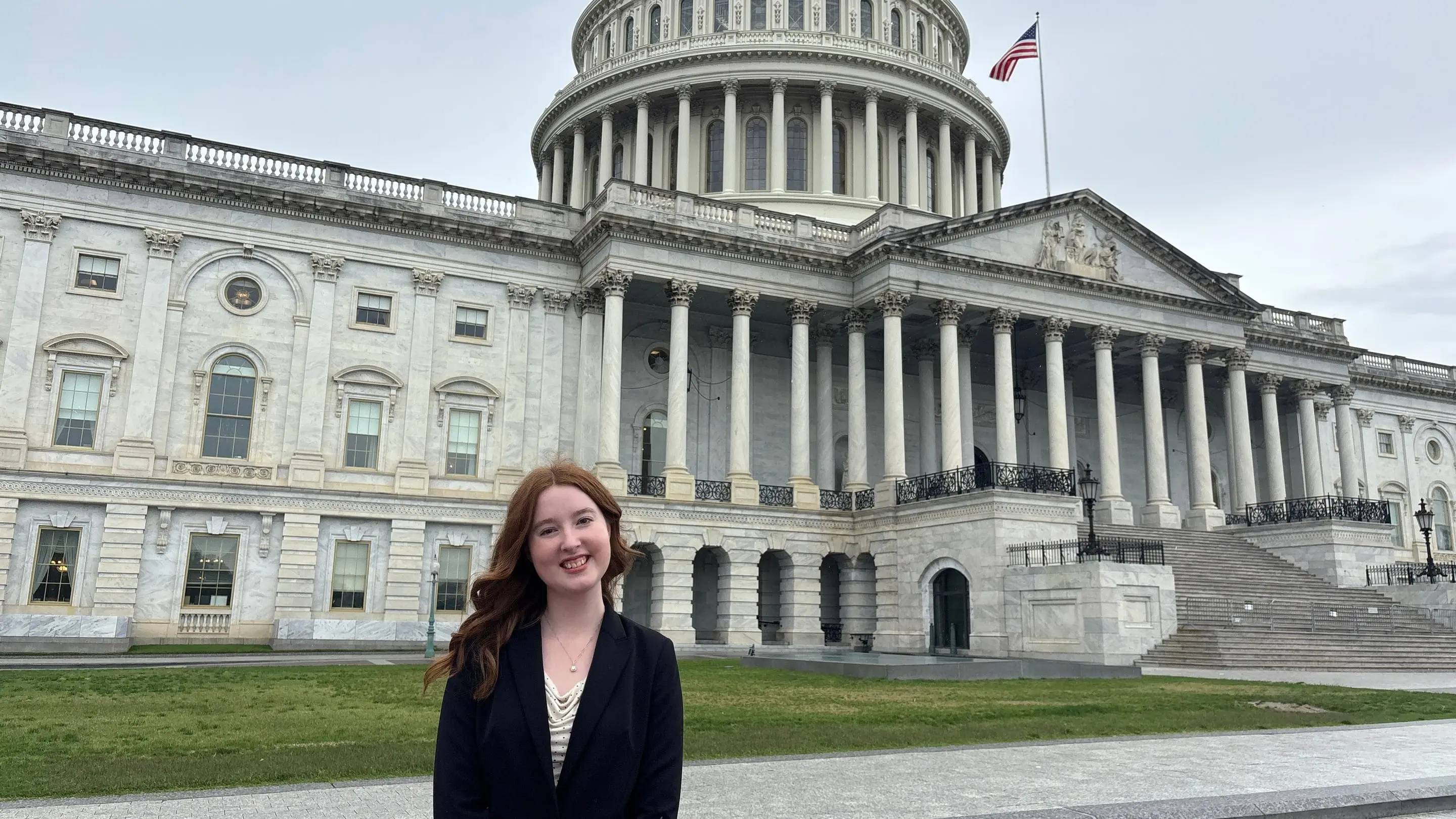 a person standing in front of a large white building with Ohio Statehouse in the background