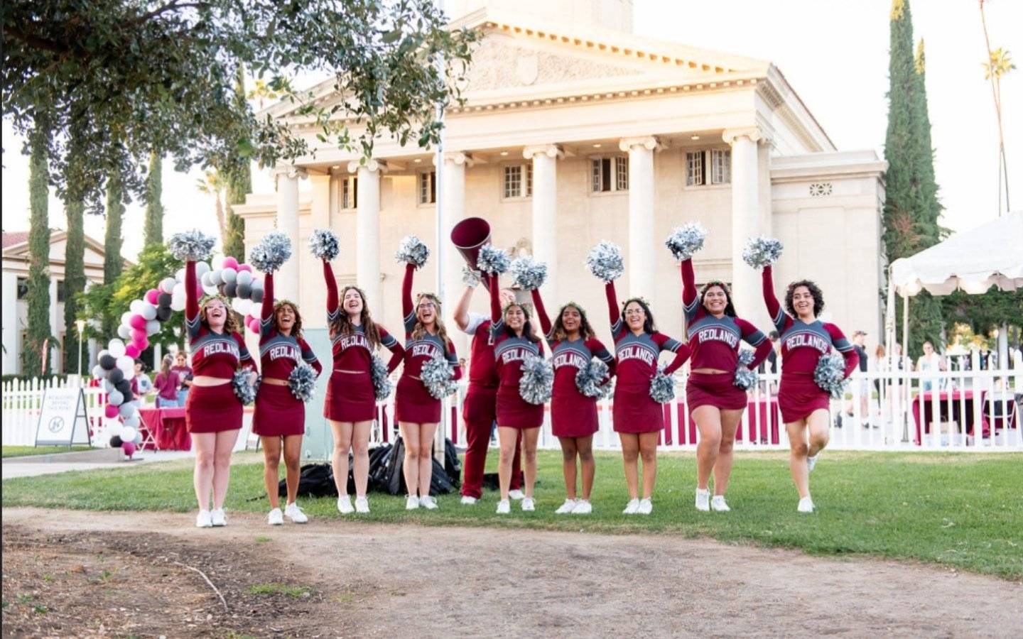 a group of cheerleaders in front of a building