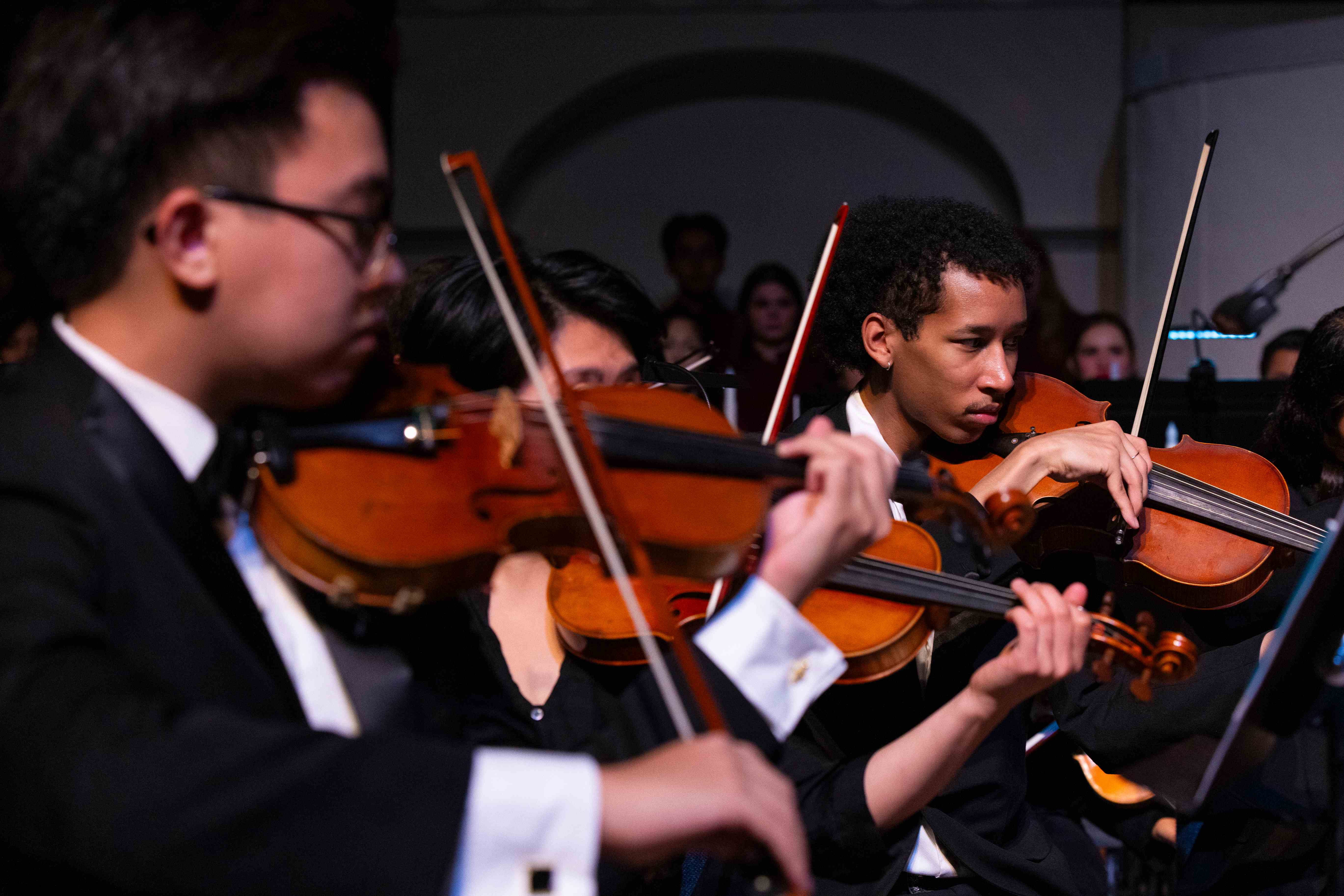 a group of people playing violins