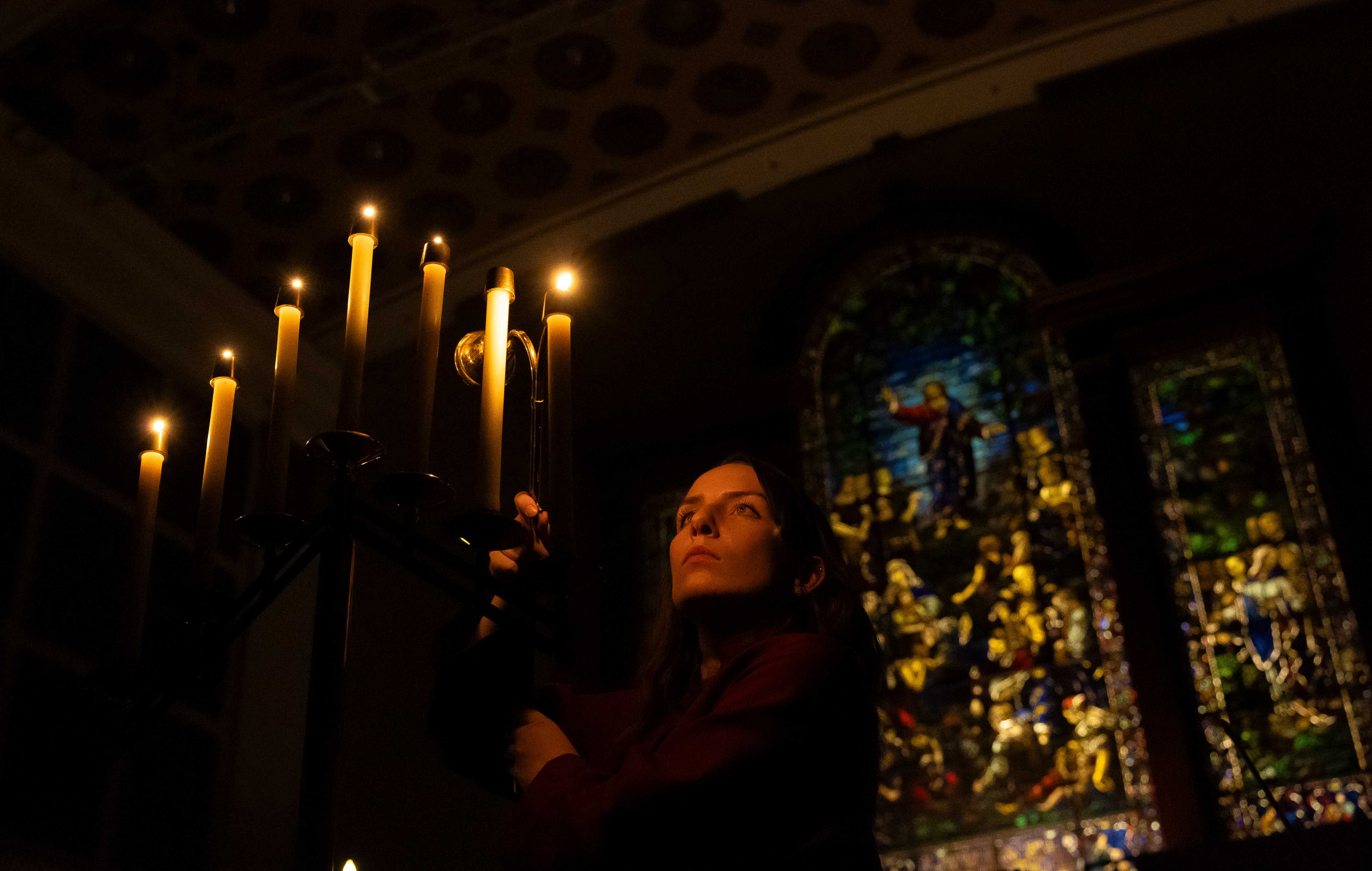 a person holding candles in a dark room