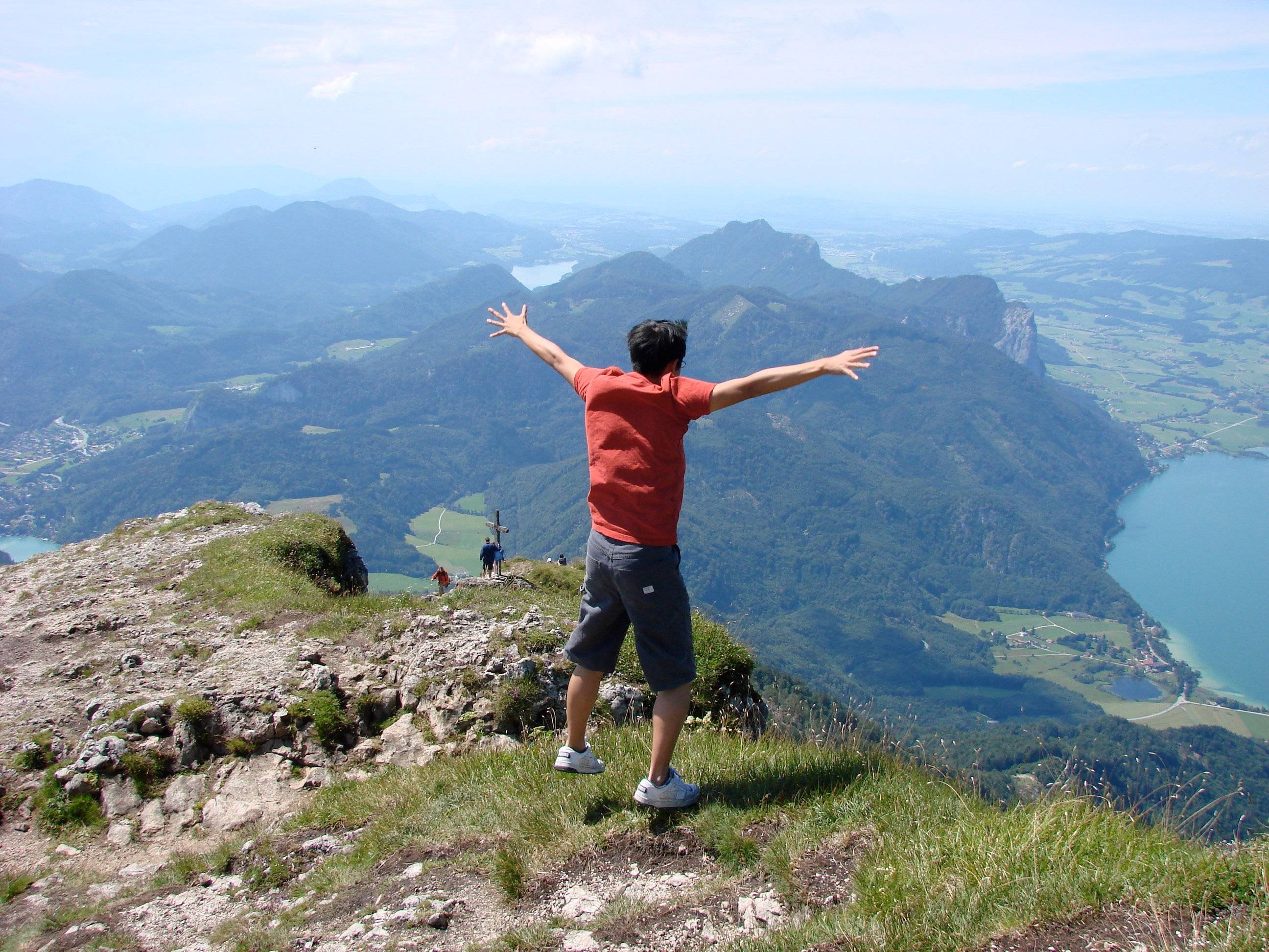 a person standing on a mountain with his arms outstretched