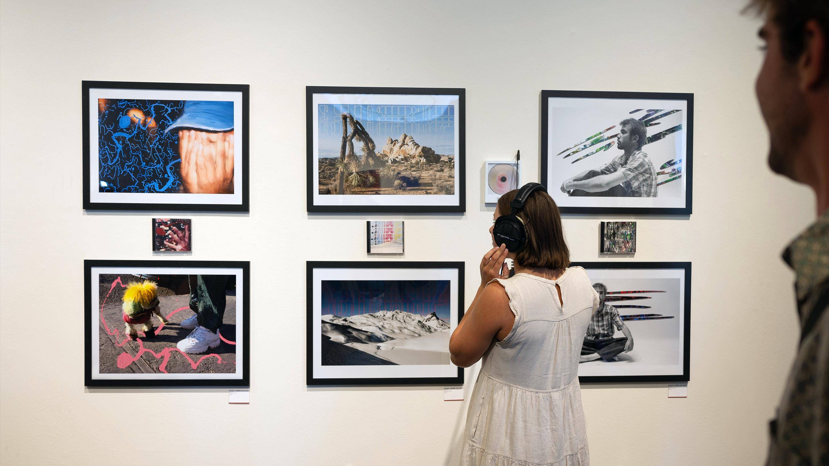 a person wearing headphones looking at pictures on a wall