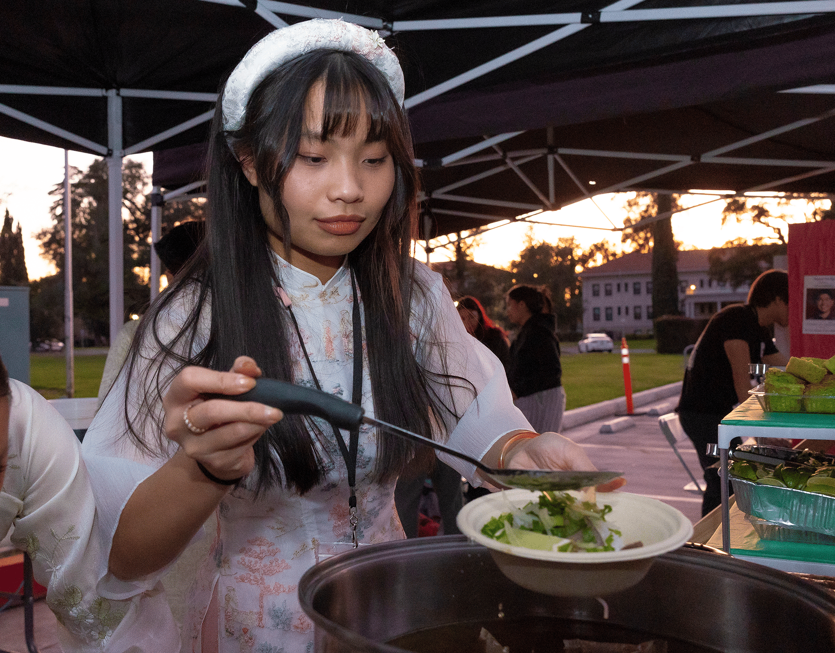 a person holding a ladle over a bowl of soup