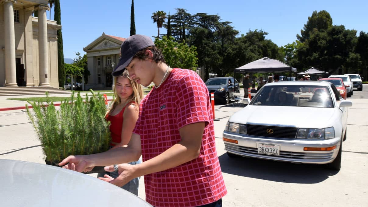 a person in a red shirt and black hat standing next to a person in a red shirt