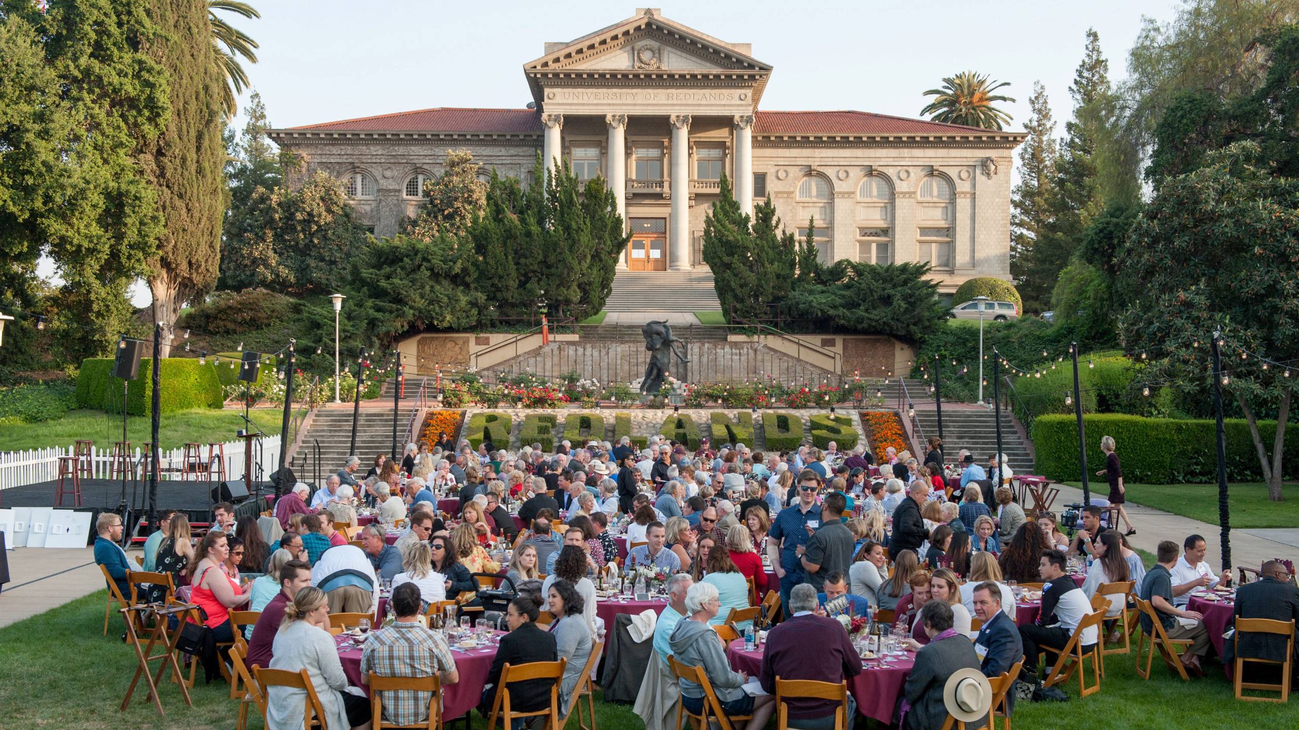 a group of people sitting at tables outside a building