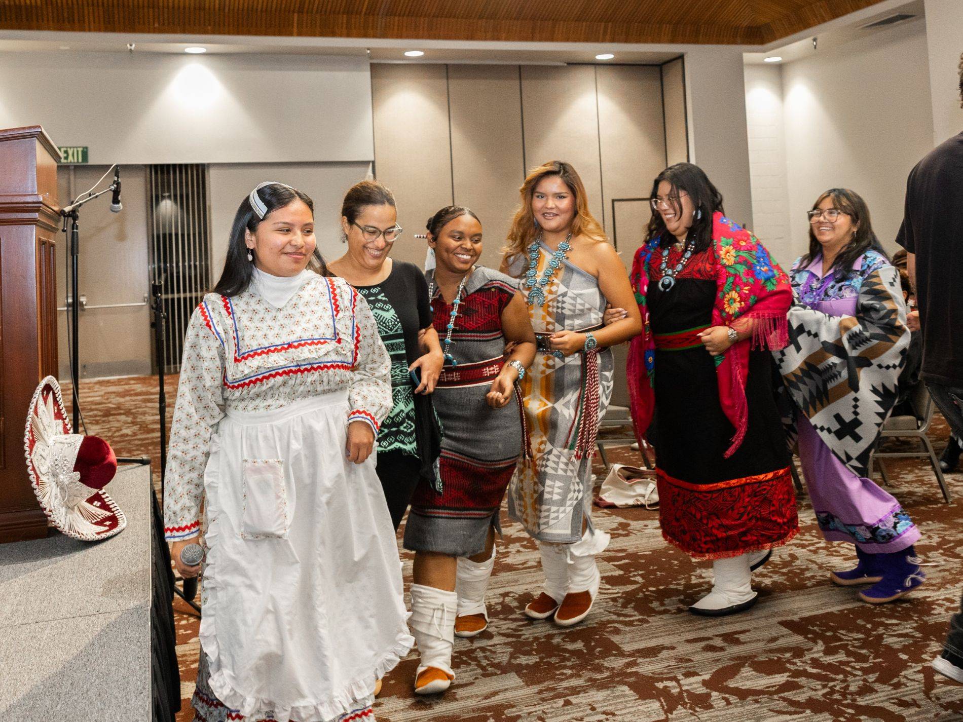 A group of students dressed in traditional regalia dance together at the Culture Not Costume event.