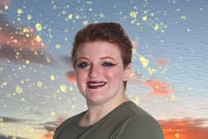 a person with short red hair and makeup